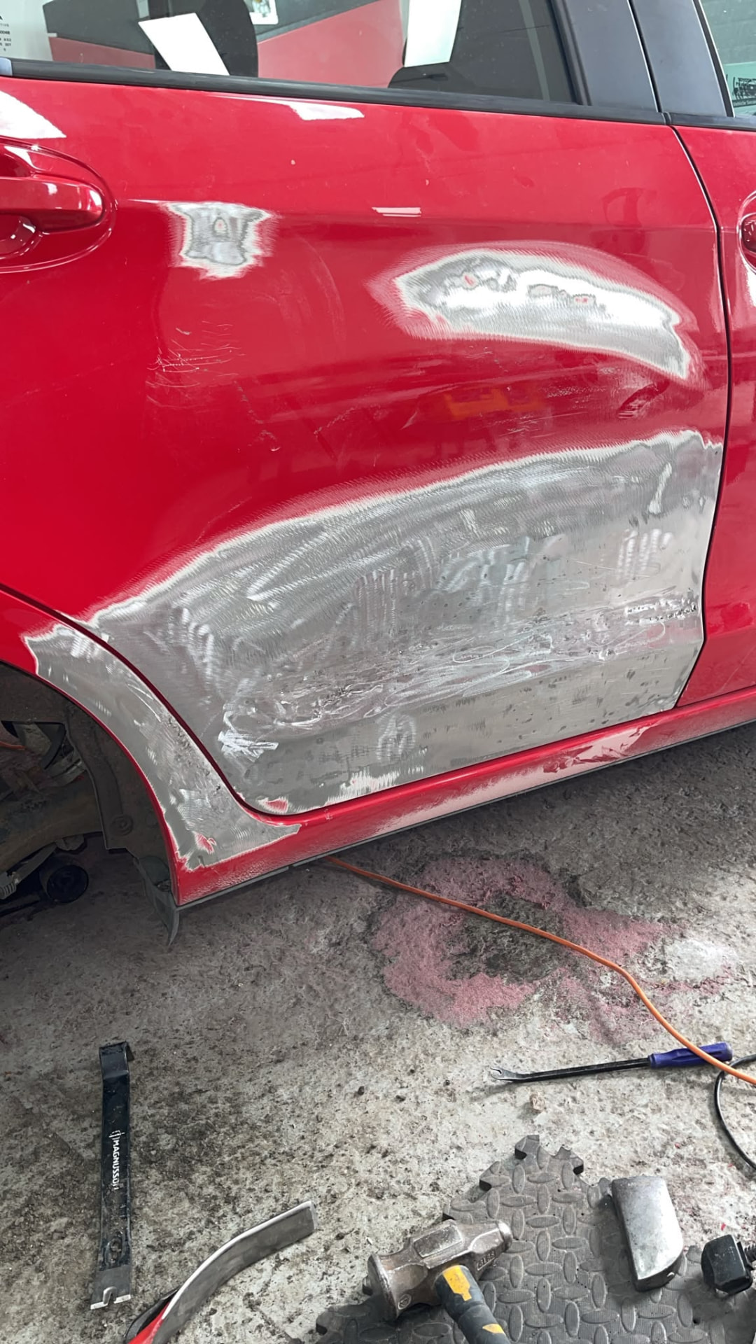 Red car door panels prepared for refinishing